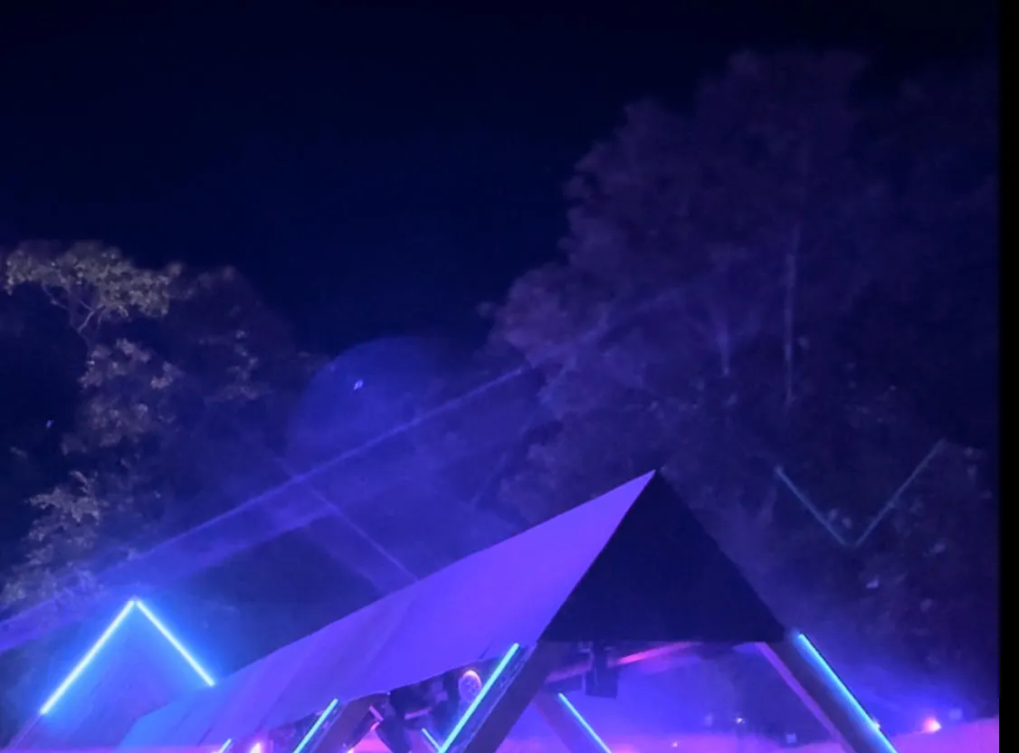 Llwyfan gŵyl olau glas gyda dawnswyr o gwmpas